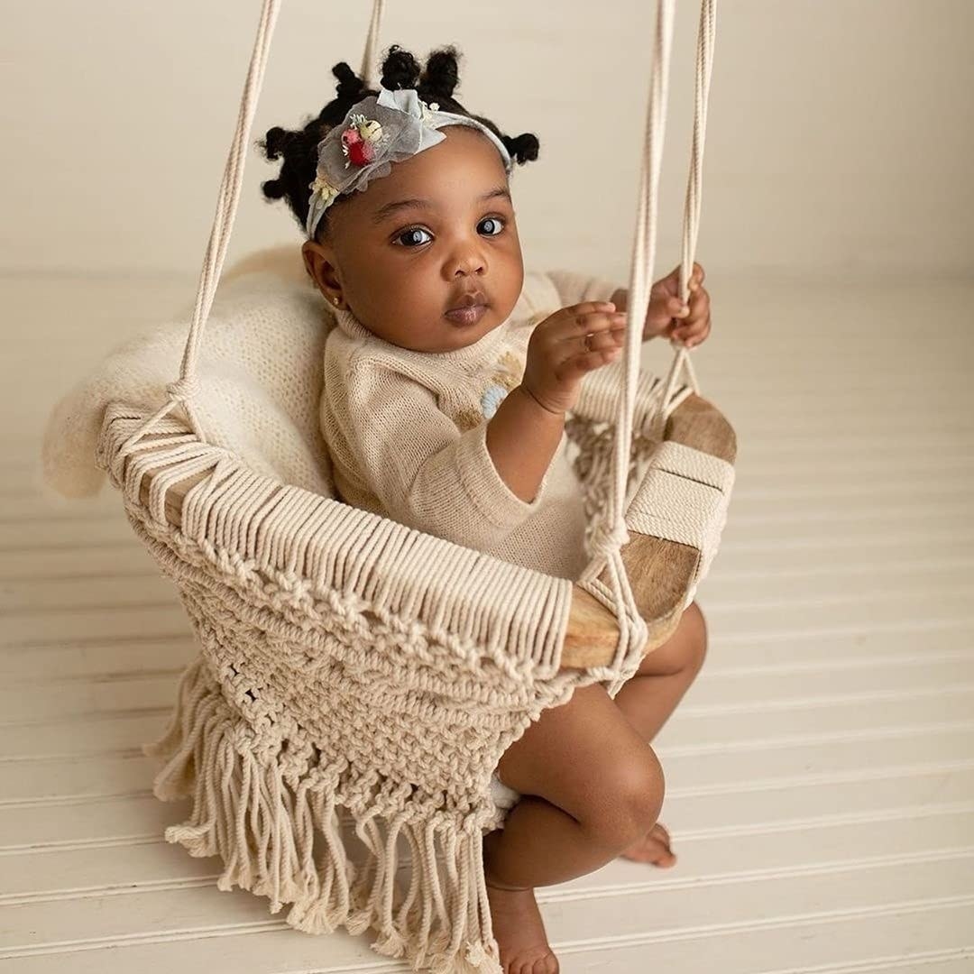 baby inside chair made with wood frame and macrame details