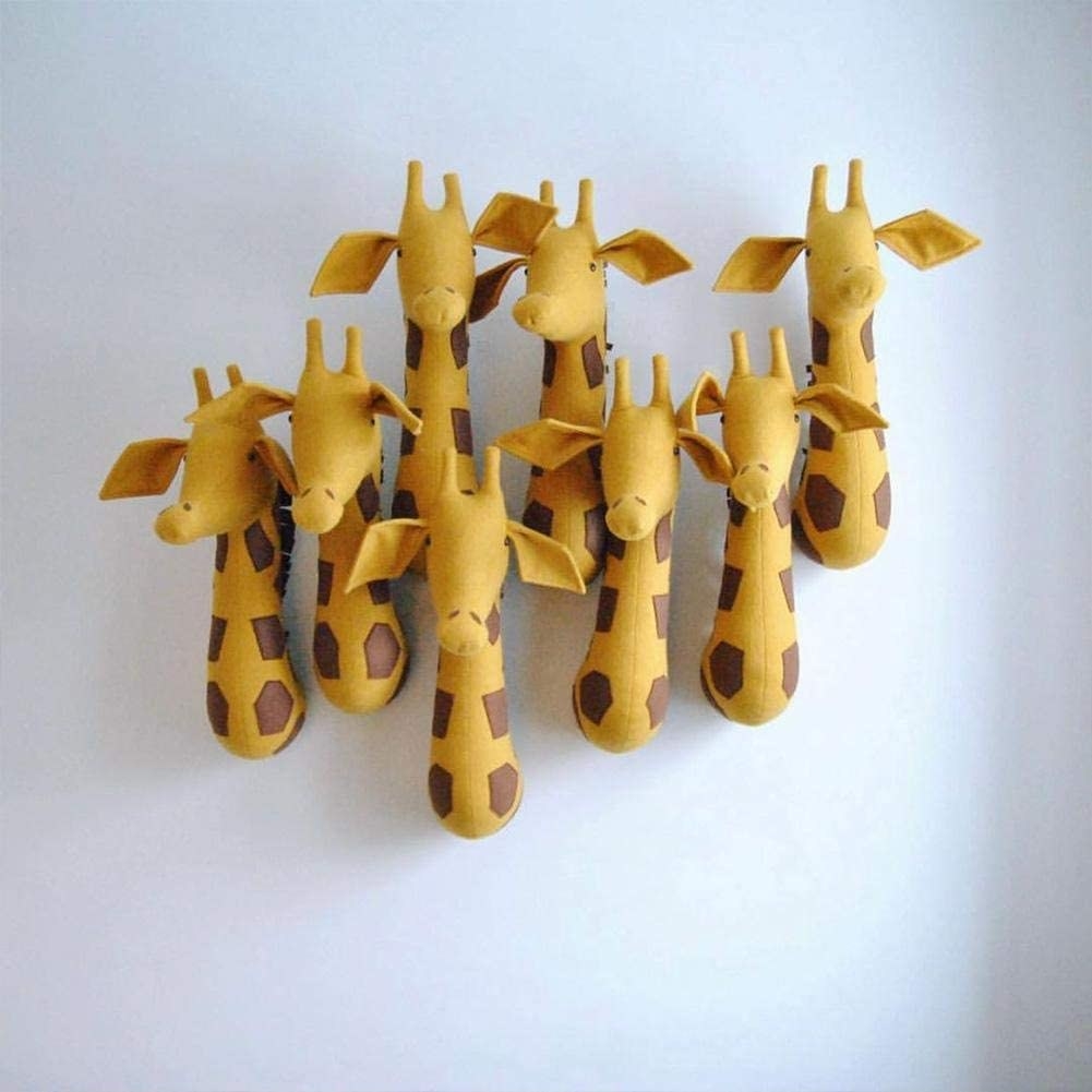 several stuffed toy giraffe heads mounted on a wall together