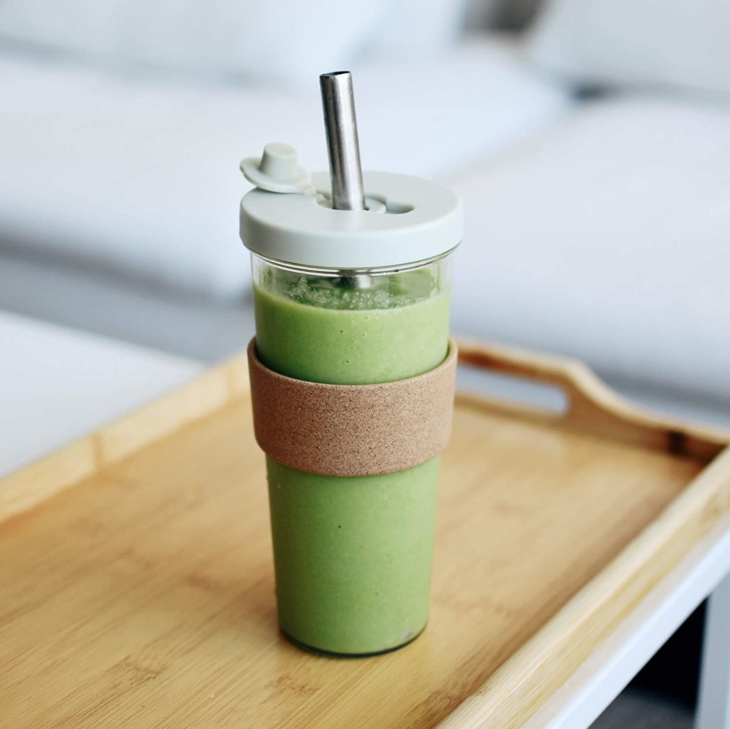 a large tumbler with an oversized straw and cork sleeve