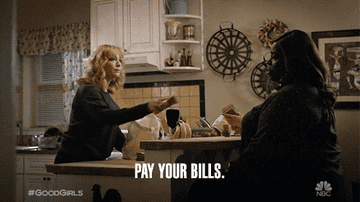 Two women sitting in the kitchen and one woman handed over money saying, &quot;Pay your bills.&quot;