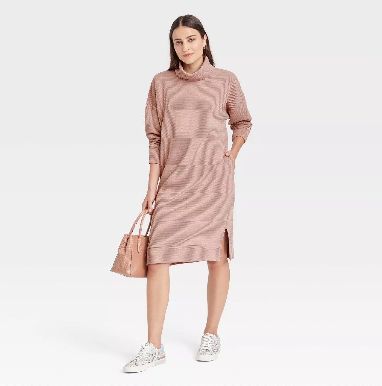 model wearing the dress in pink with white sneakers carrying a pink handbag