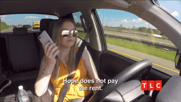 A woman driving holding her phone to her ear saying, &quot;Hope does not pay the rent&quot;