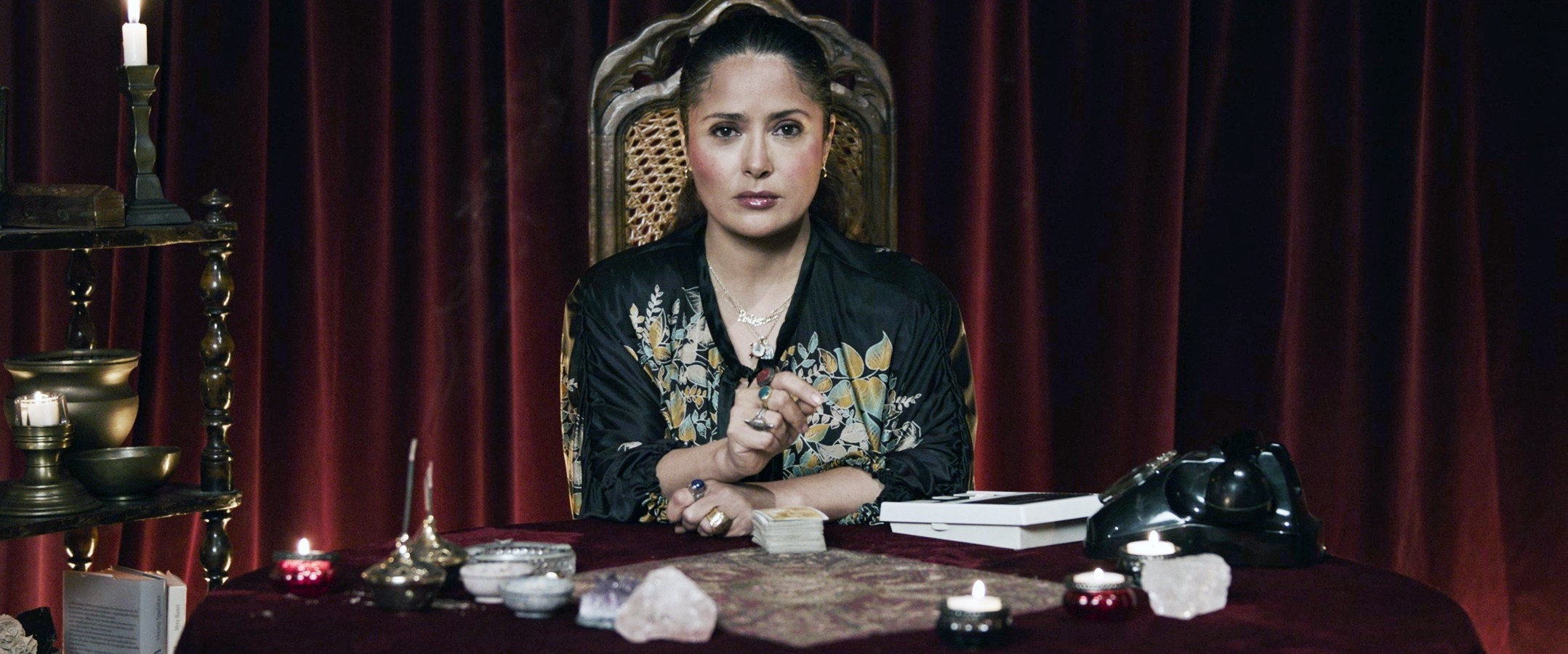 Salma sitting at a desk with a deck of cards for a photo