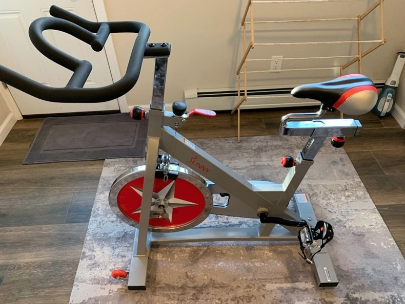 silver exercise bike with red flywheel, black handle bars, black silver and red seat