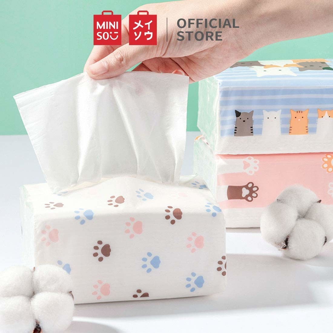A tissue box on a table next to cotton balls