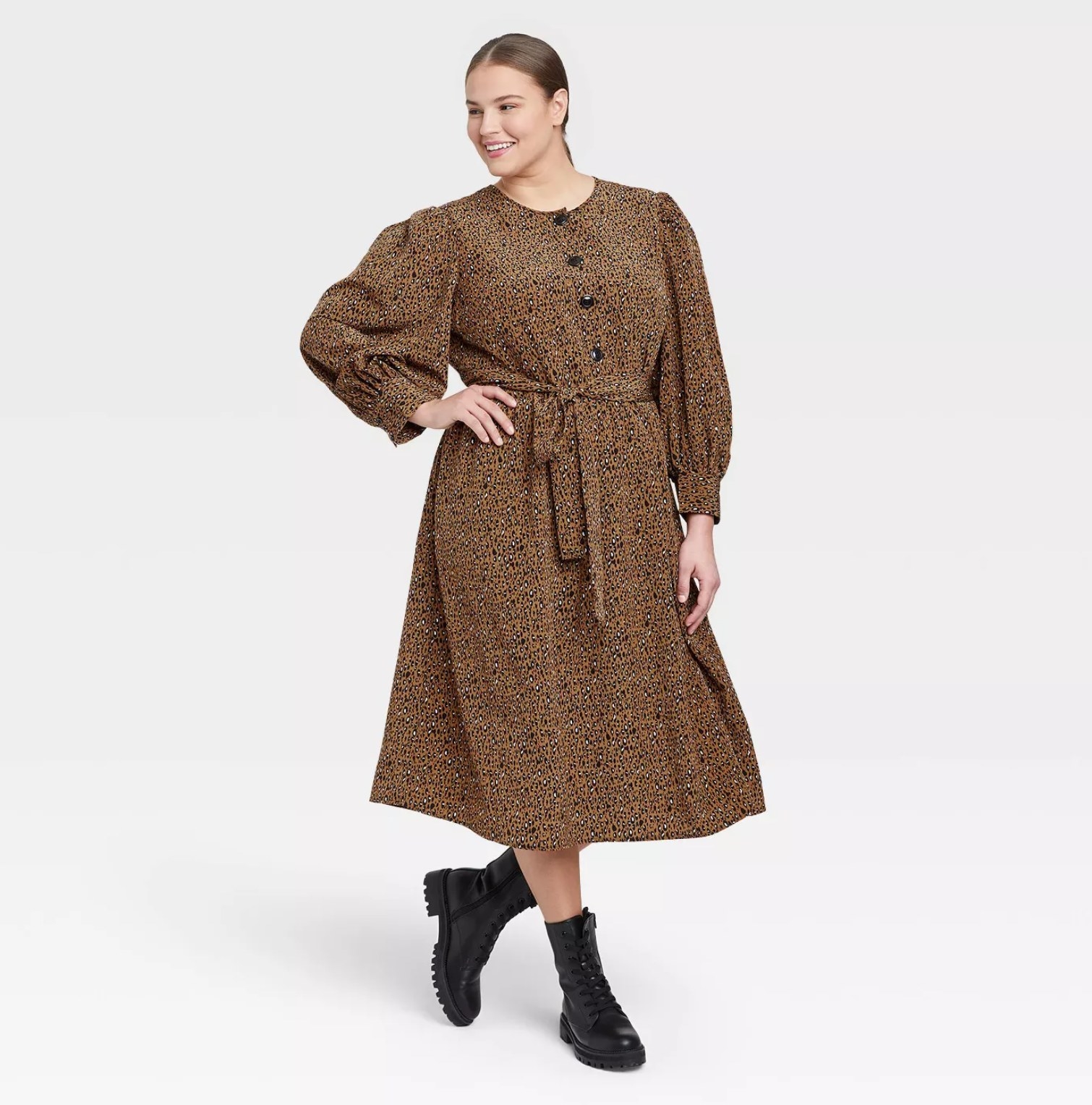 model wearing the dress in brown with black buttons and black boots