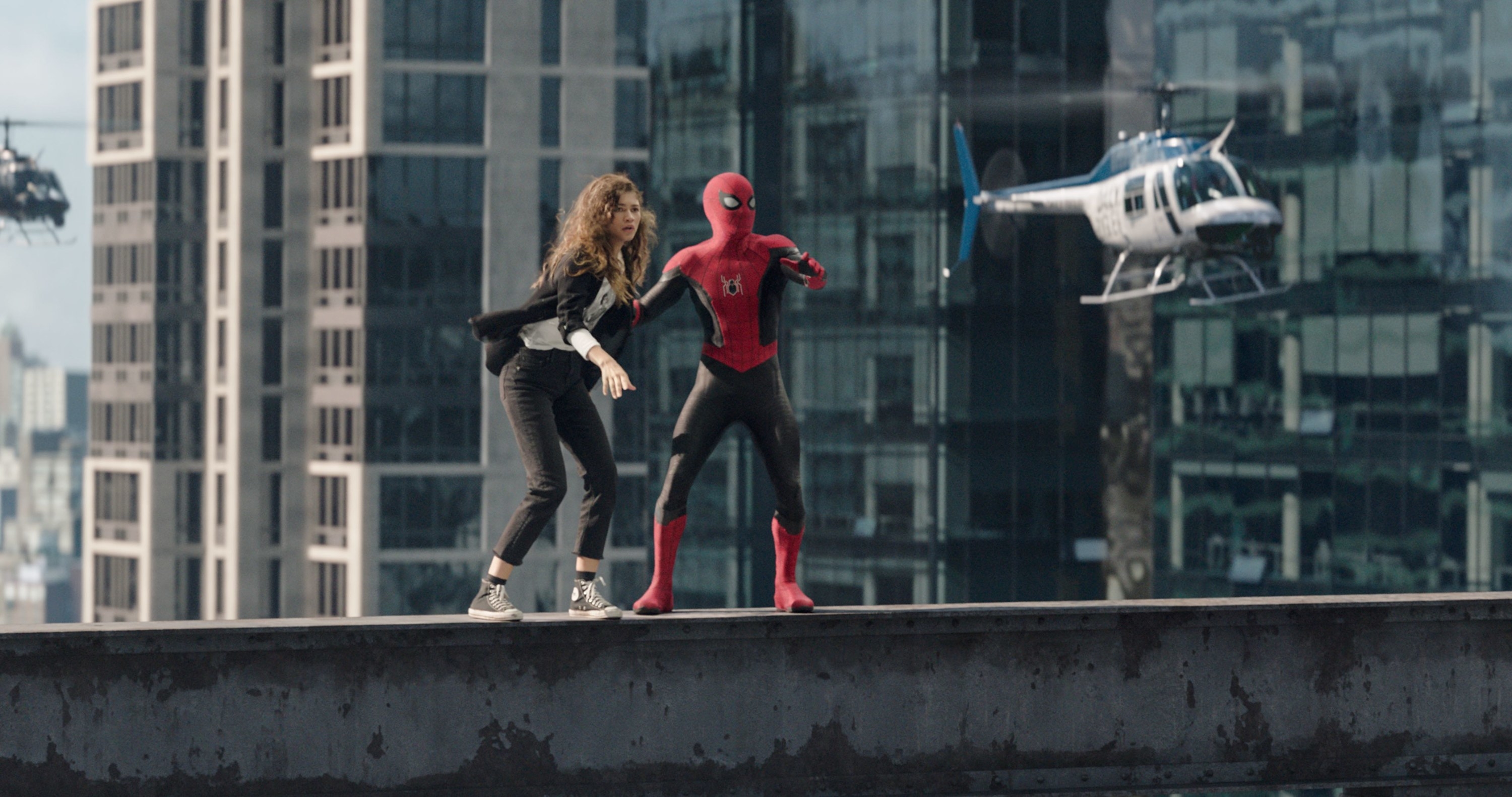 Spider-Man and MJ standing on a beam as helicopters surround them