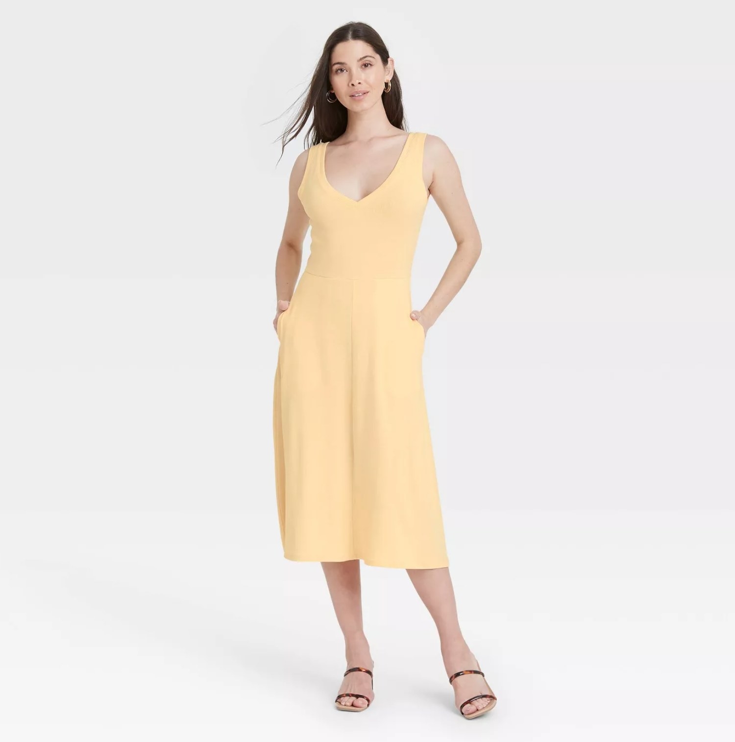 model wearing the dress in yellow with strappy sandals