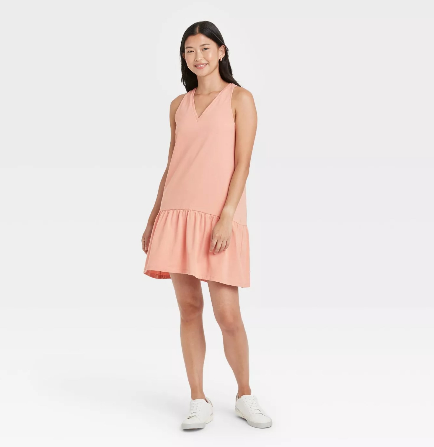 model wearing the dress in pink with white sneakers
