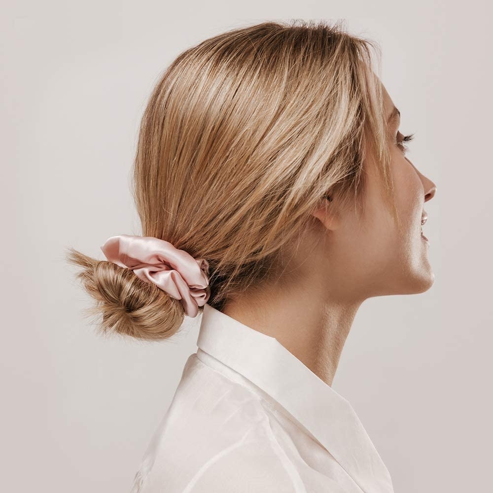 a person wearing one of the silk scrunchies in their hair