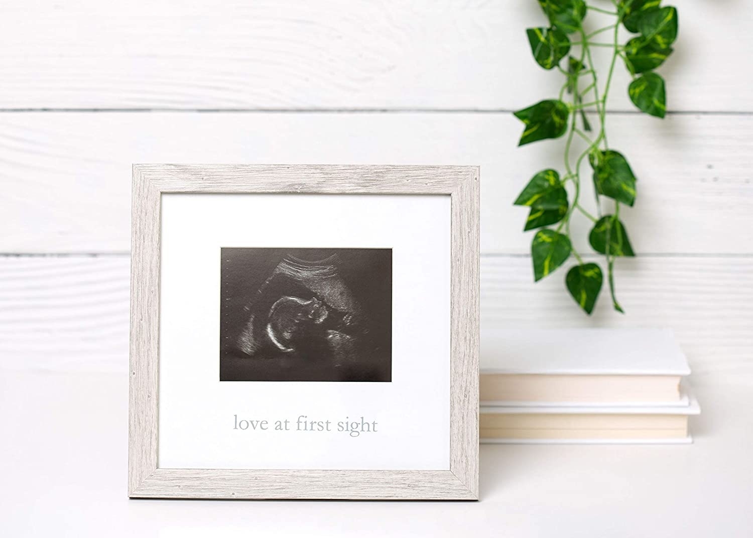 rustic frame with sonogram inside and the phrase love at first sight written on the bottom