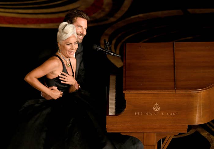 Gaga and Bradley smile at the audience after they finish their performance