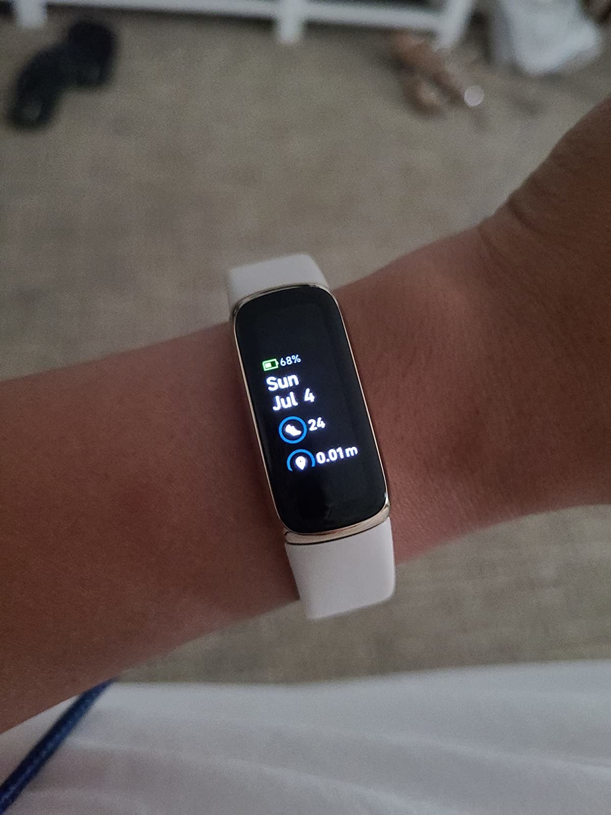 person wearing a fitbit luxe with a white band on their wrist