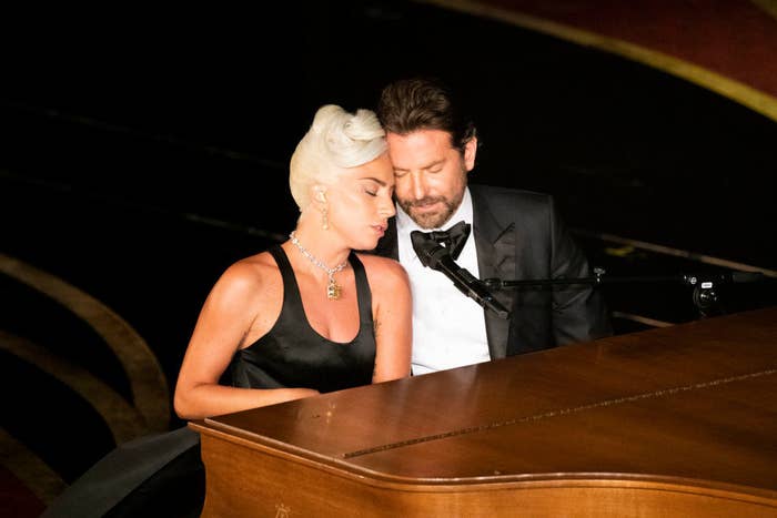 Lady Gaga and Bradley sitting next to each other at the piano as they perform