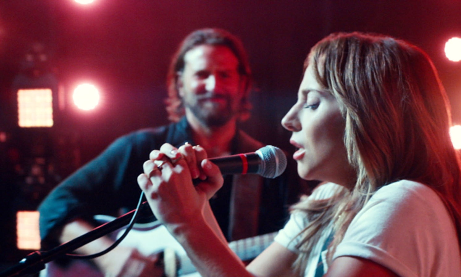 Gaga singing in a scene from the film as Bradley&#x27;s character plays the guitar and watches her