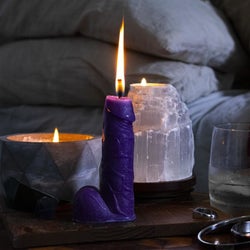 Purple realistic penis candle with burning wick