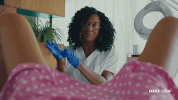 A doctor putting on gloves for a pelvic exam