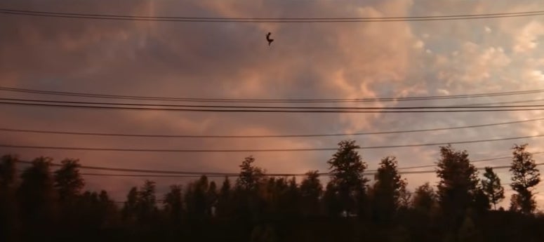 Spider-Man swinging over some trees next to some power lines in &quot;Spider-Man: No Way Home&quot;