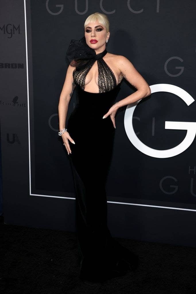 Lady Gaga on the red carpet in halter form-fitting dress with a bow detail on the right shoulder