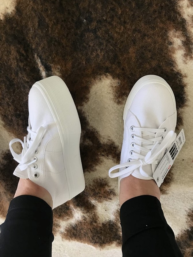 Reviewer wearing all white platform sneakers
