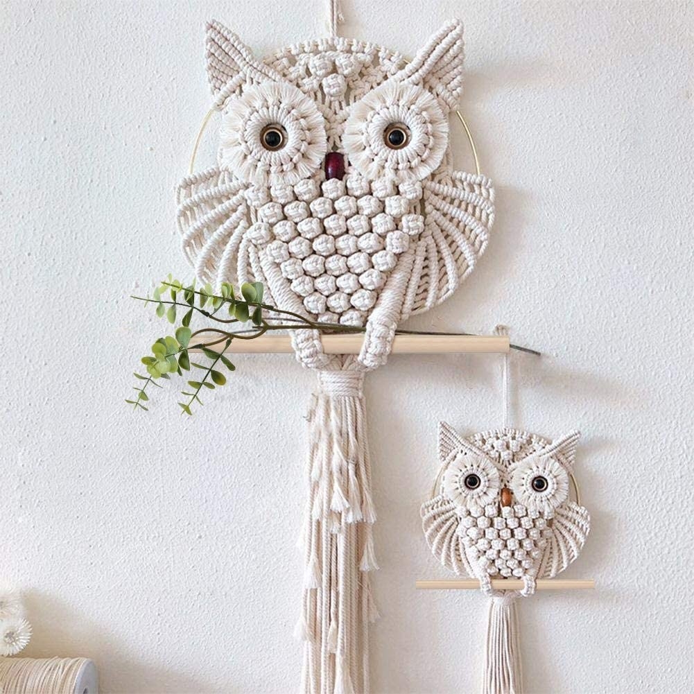 large and small owls on wooden dowels