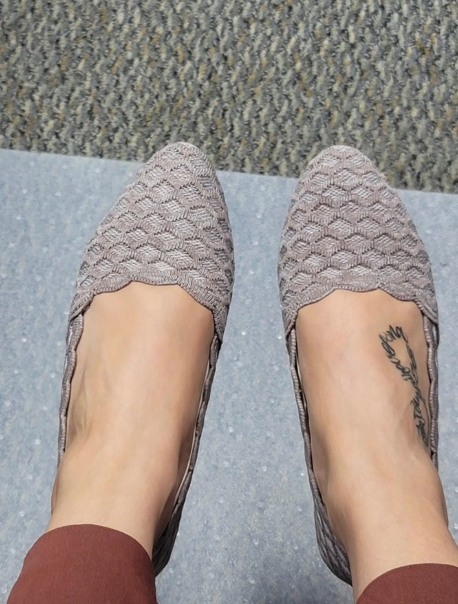 Reviewer wearing taupe colored woven flat with pointed toe