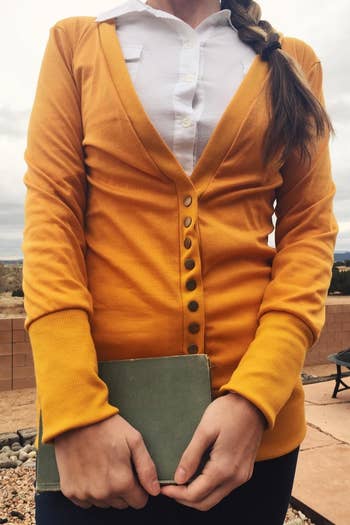A reviewer wearing the cardigan in mustard