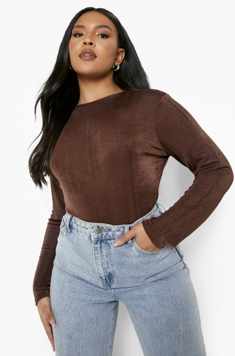 model in long sleeve brown bodysuit and high-rise jeans