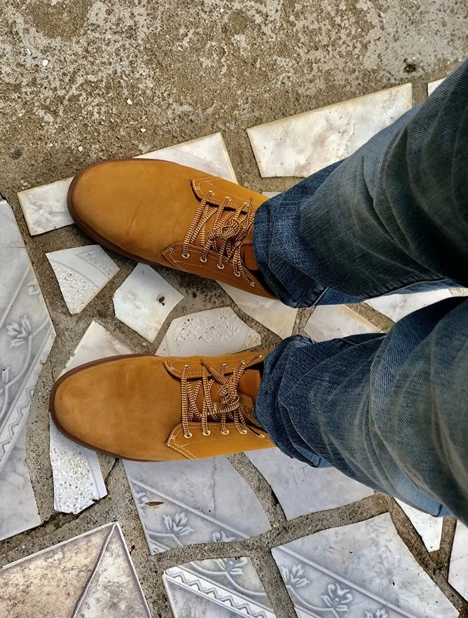 Reviewer wearing classic colored, tan Timberland sneakers with jeans