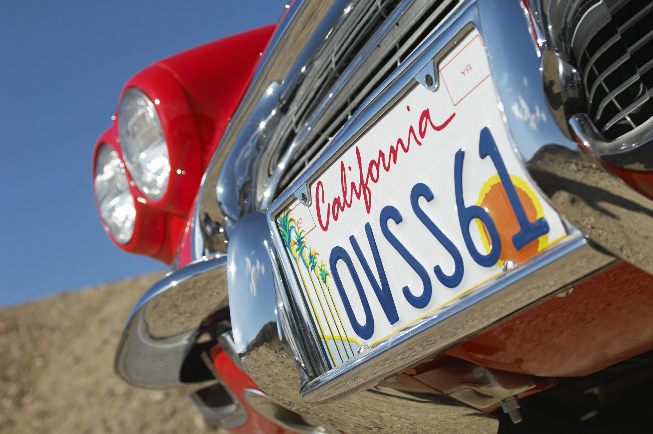 A California license plate on a red car