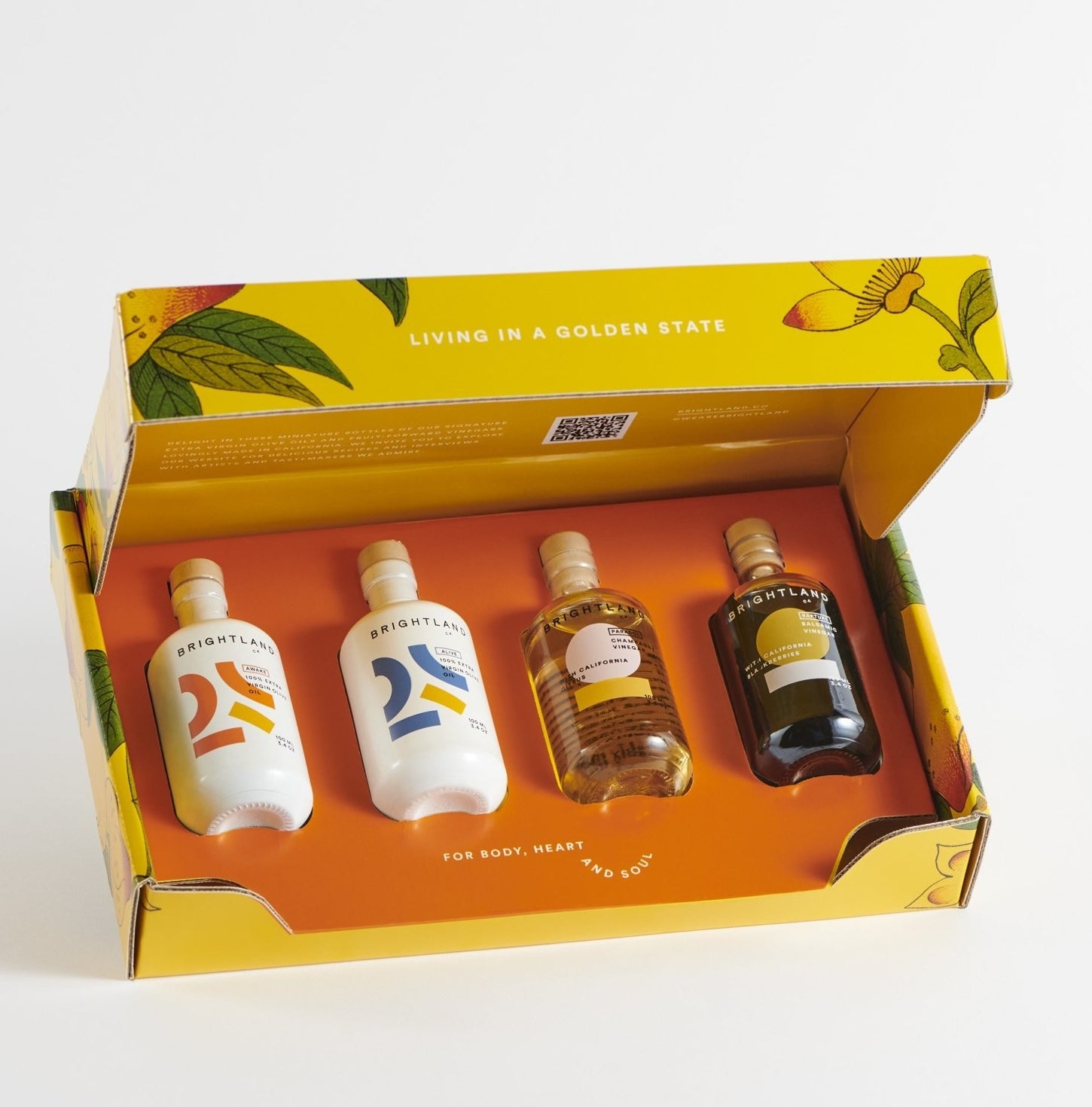 A yellow box with four small olive oil bottles inside it