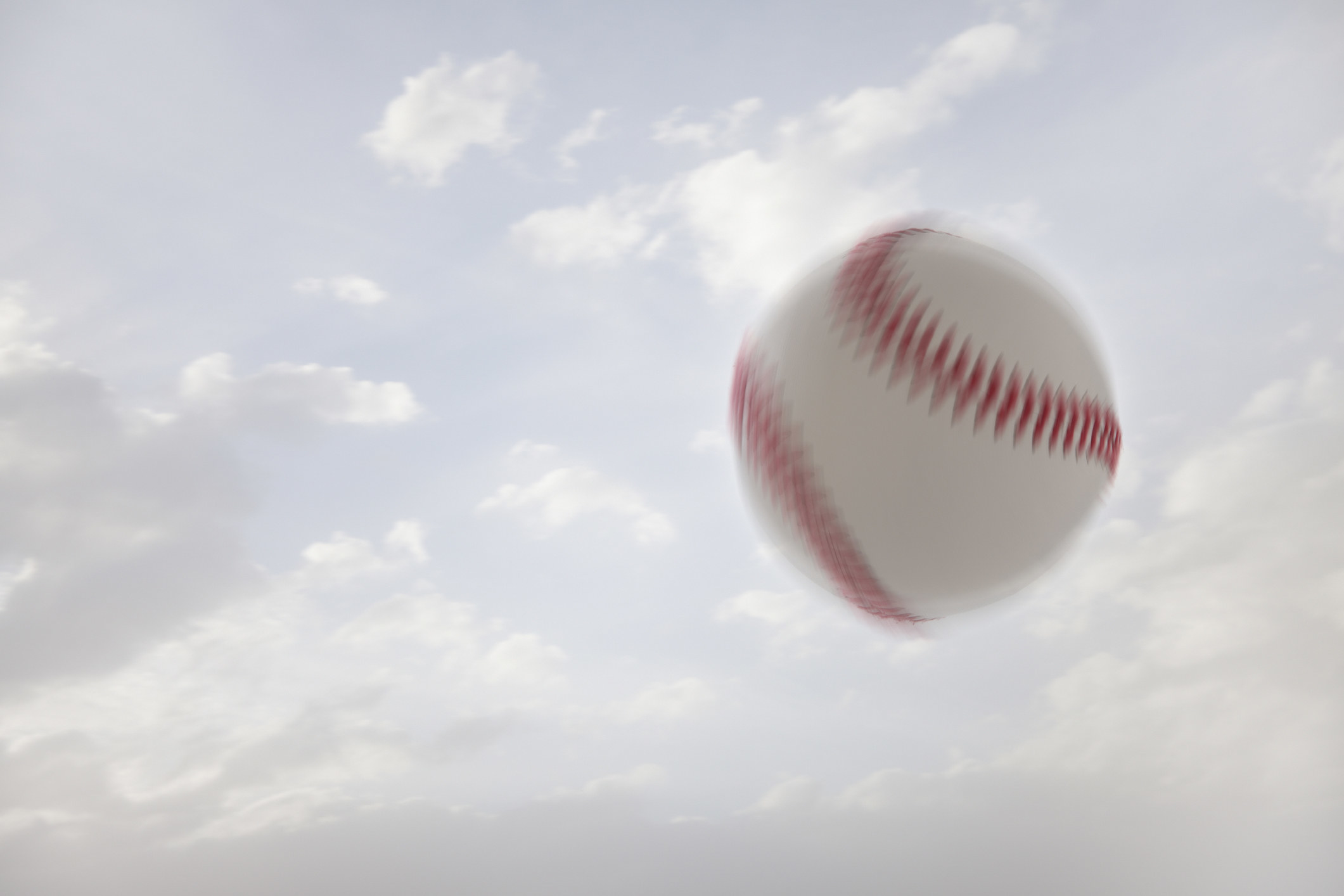 A blurry, speeding baseball in the sky