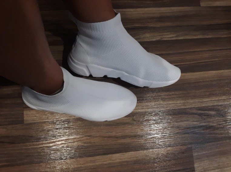 Reviewer wearing all white high top knit sneaker