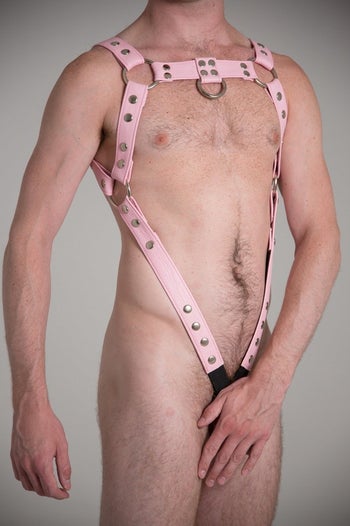 Model wearing pink full body harness with cock ring