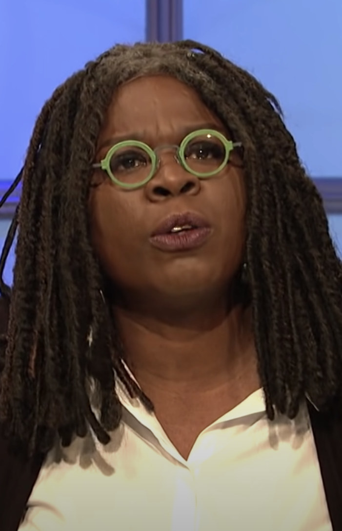 Jones with round, colorful glasses, a buttoned-down shirt, and dreadlocks