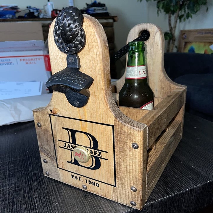 a reviewer photo of the beer caddy with a paint "B" on the side and an attached black bottle opener