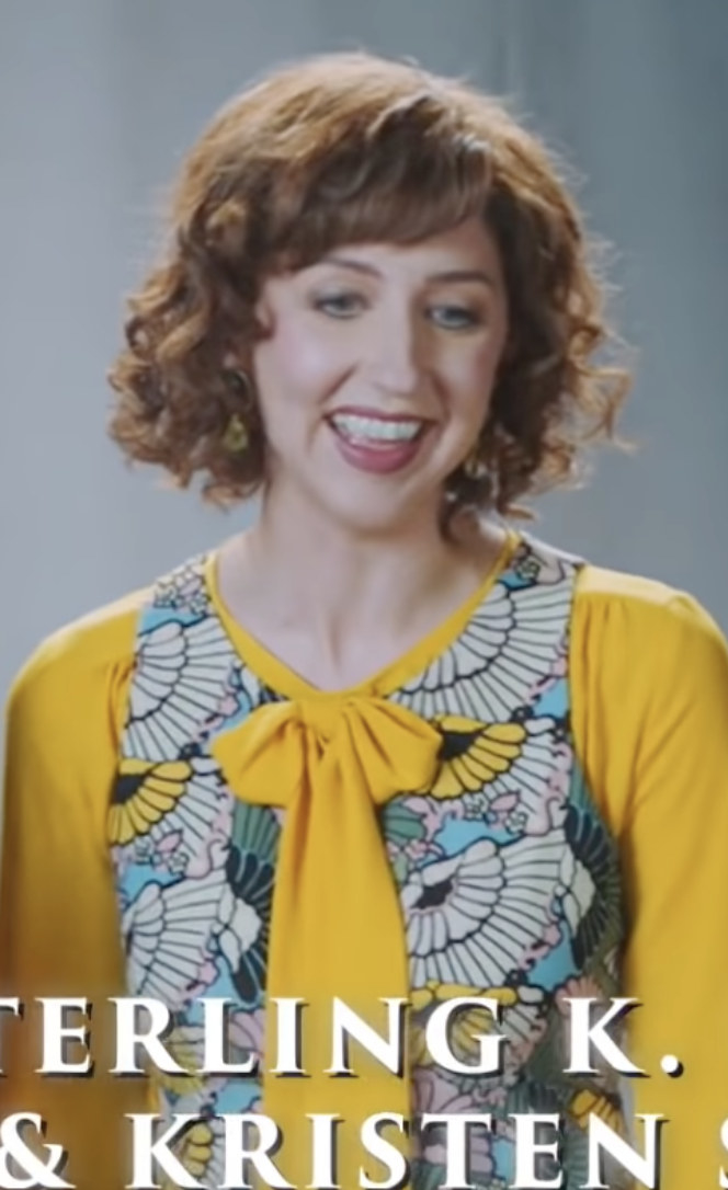 Gardner with short, curly hair wearing a bright colored dress
