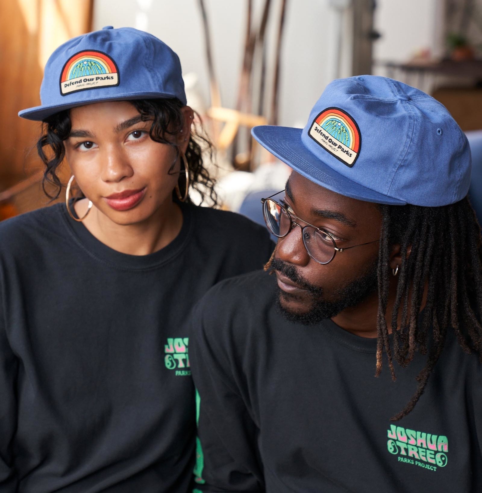 models wearing the blue "Defend Our Parks" hats