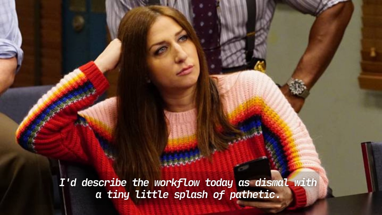 Chelsea Peretti, resting her head on one hand and holding her phone, playing her character as Gina Linetti for the sitcom Brooklyn Nine-Nine
