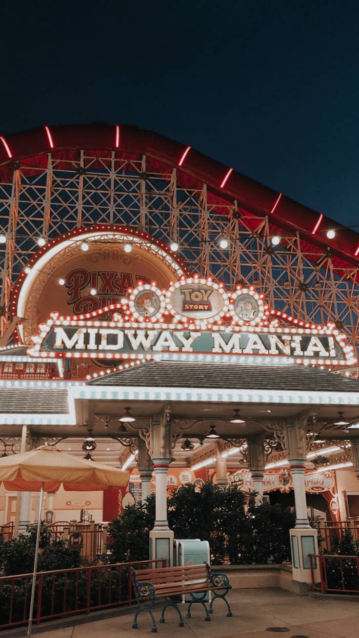 the roller coaster called toy story midway mania, a tall coaster with a sign with light-up letters with the title of the ride