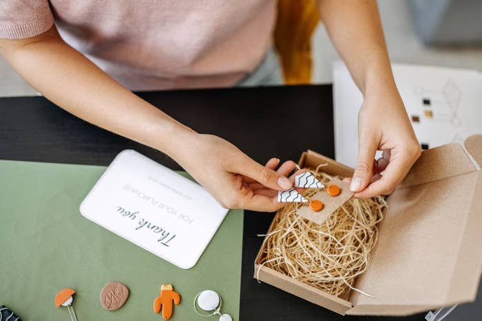 Woman packing up a pair of earrings to ship them