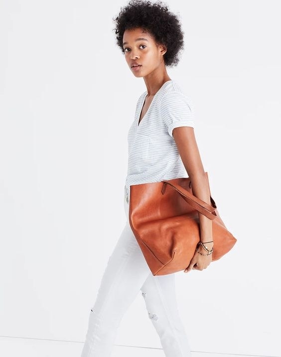 Model carrying the tan tote bag in her arm