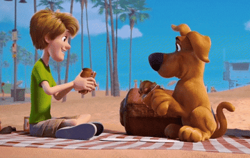 shaggy and scooby from &quot;scooby doo&quot; sat on a blanket at the beach eating sandwiches