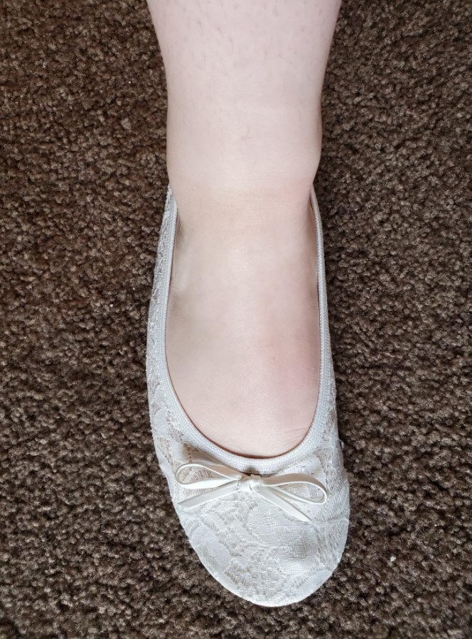 reviewer wearing white pair of flats
