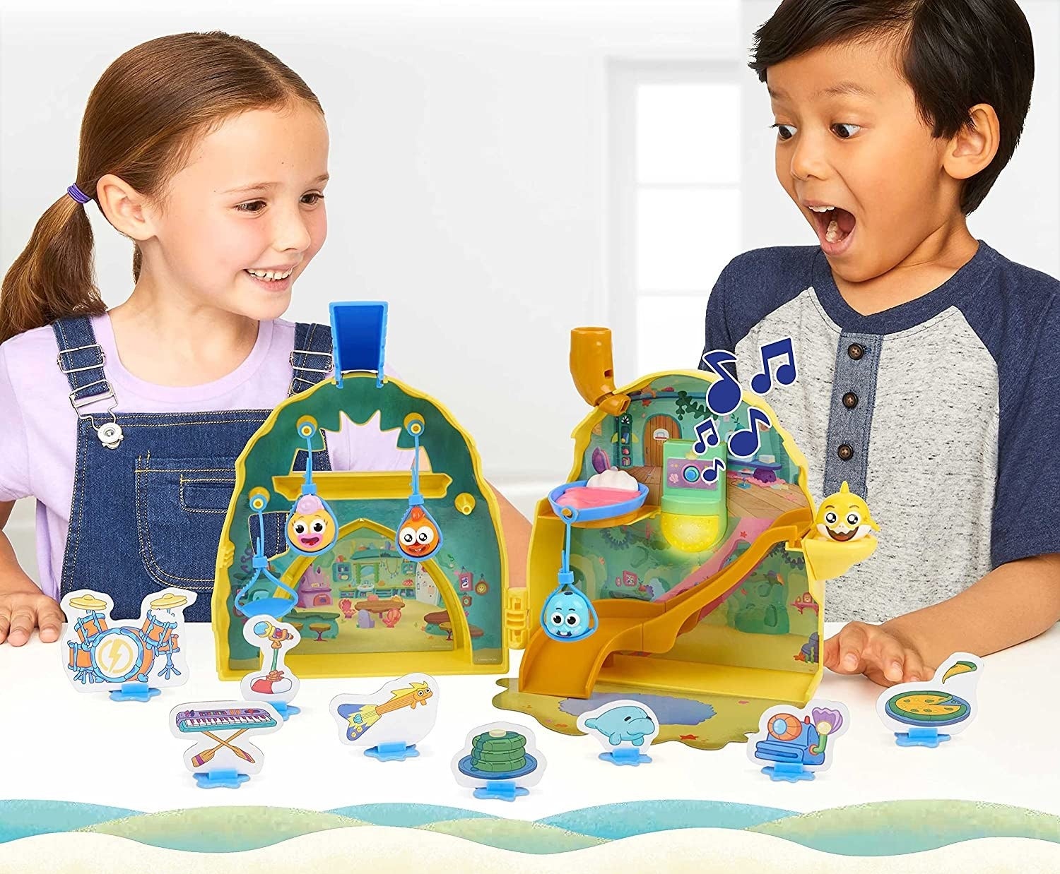 two kids playing with the baby shark play set