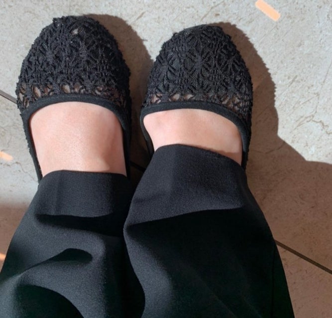 A reviewer wearing black flats and black business pants