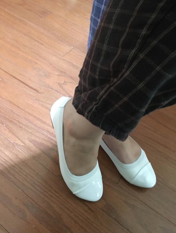Reviewer wearing white flats with colorful plaid pants