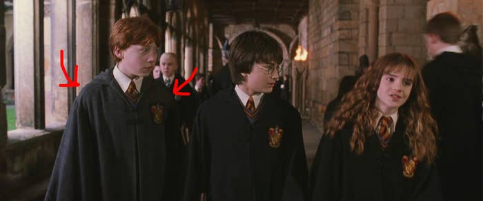 Ron in lighter robes than Harry or Hermione