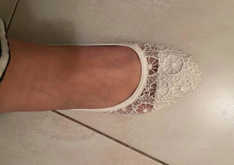 A reviewer in white floral flats