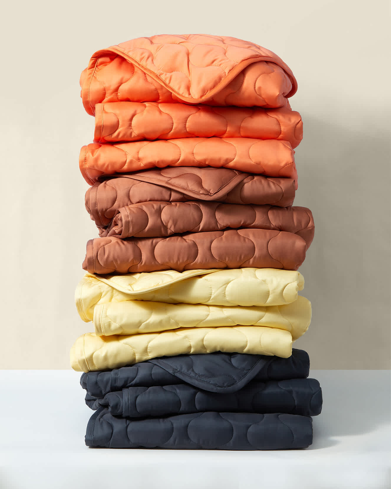 a stack of puffer blankets in various colors